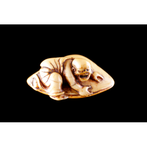 Japanese Carved Ivory Netsuke Depicting a Monk Dressed in His Flowing Robes his Hand Trapped in an Huge Clam